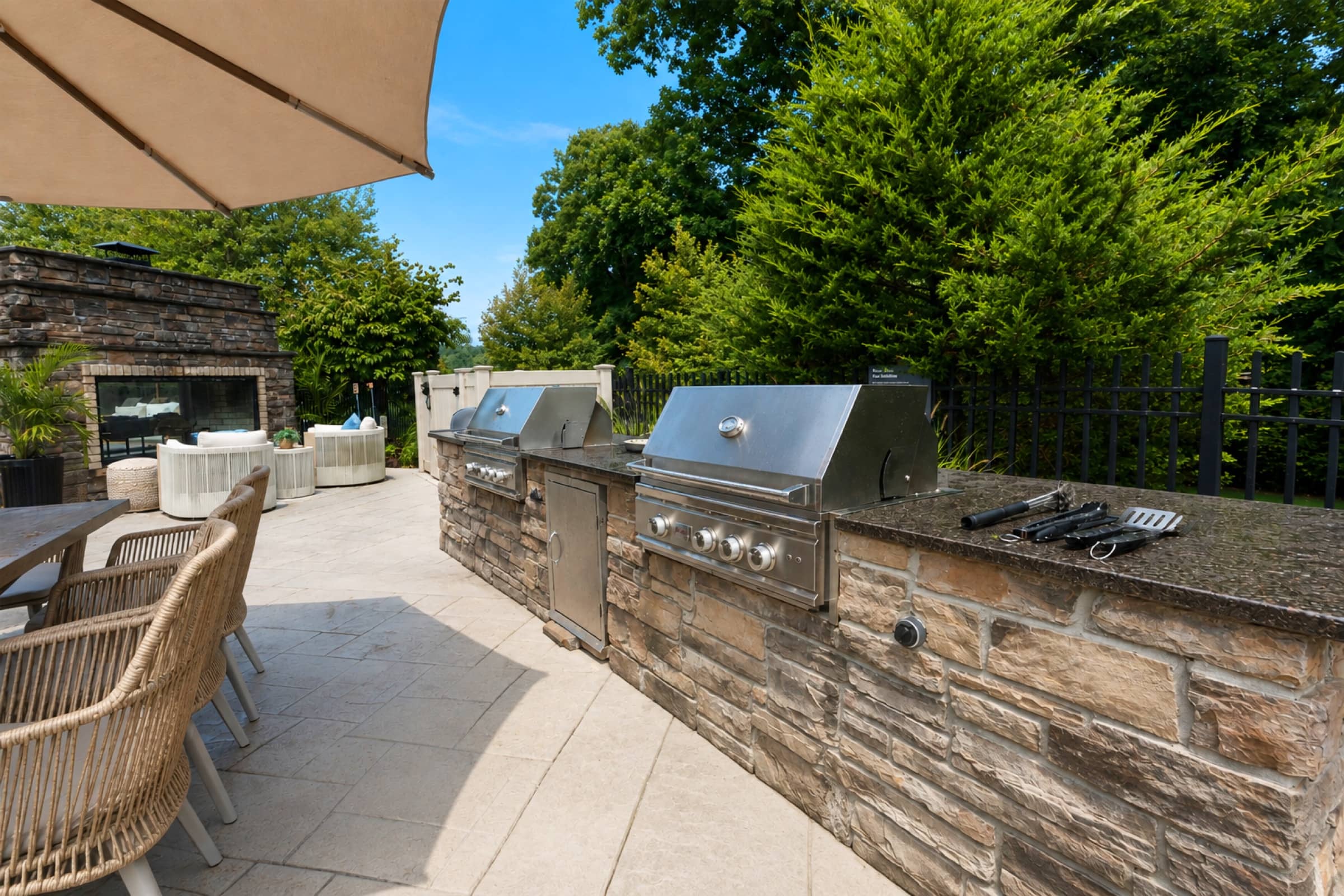 Outdoor kitchen at White Oaks — two built-in stainless grills in a stone counter
