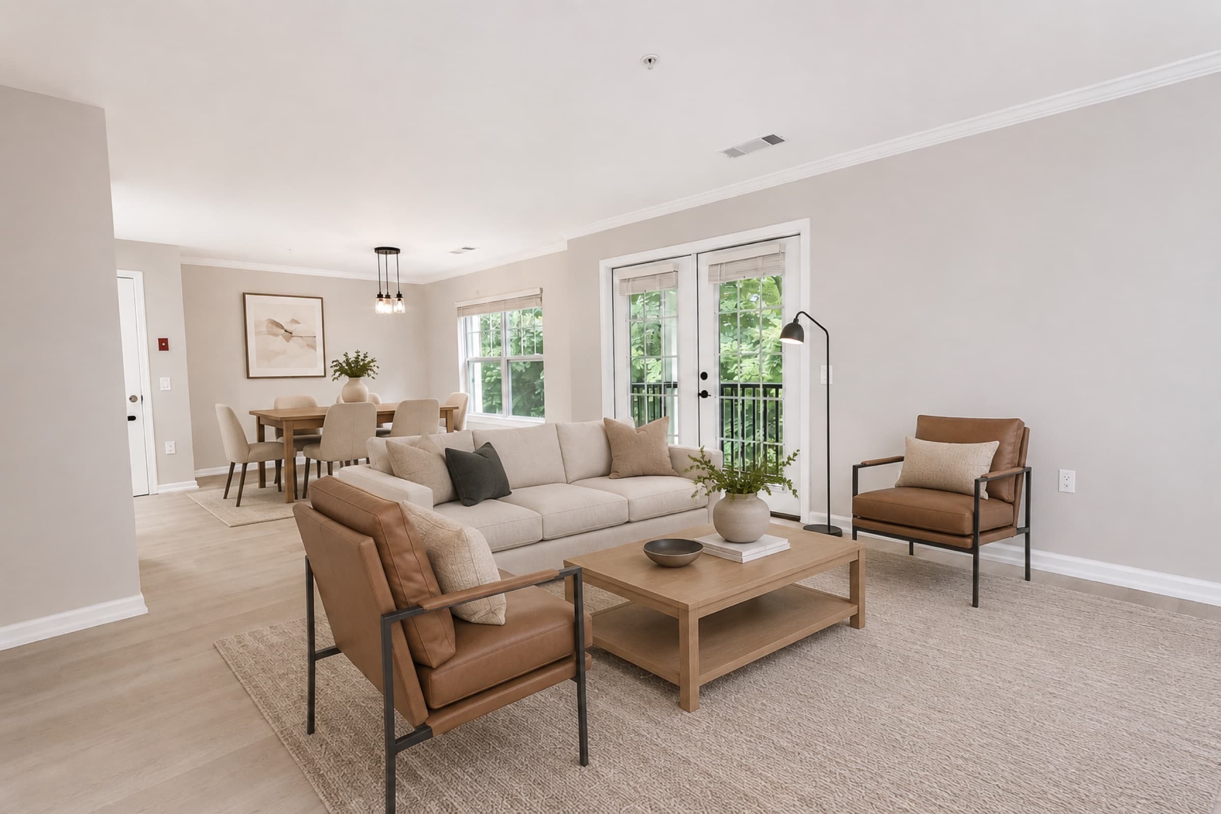 Open living and dining room in a White Oaks townhome, French doors to the deck (virtually staged)